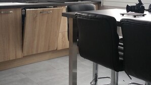 A modern kitchen with a gas stove, wooden cabinets, and a dining area with black chairs. - House / Villa - MORIEUX (Morieux)