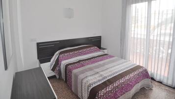 3 dormitorios y tabla de planchar con plancha