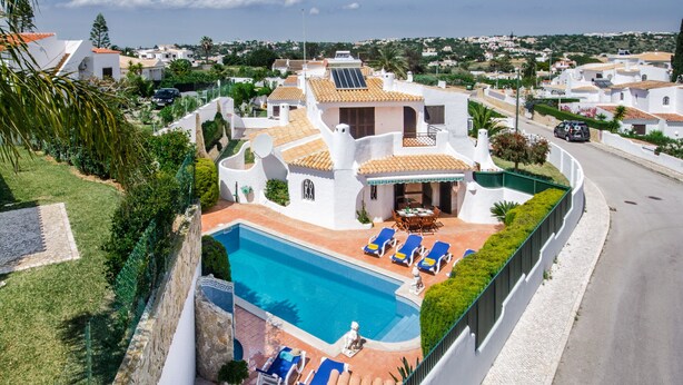 Propiedad residencial con piscina, sillas de descanso y zona de patio.