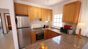 Una cocina moderna con armarios de madera, electrodomésticos de acero inoxidable y encimera de granito.