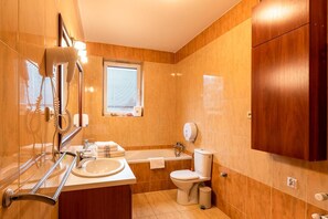 A bathroom with a bathtub, toilet, and sink. - Hotel Kasztelan (Dobczyce)