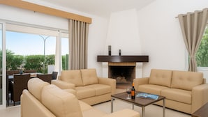 A modern living room with two beige sofas, a coffee table, and a fireplace. - Villa Sete, Beautiful Spacious Private 5 Bedroom Villa, Albufeira Town (Albufeira)