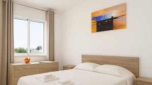 A bedroom with a bed, a nightstand, a dresser, a window with curtains, and a painting on the wall. - Villa Sete, Beautiful Spacious Private 5 Bedroom Villa, Albufeira Town (Albufeira)