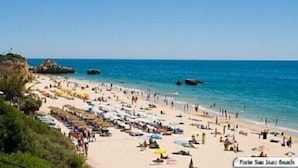 A beach with numerous umbrellas and people, indicating a busy public beach setting. - Villa Sete, Beautiful Spacious Private 5 Bedroom Villa, Albufeira Town (Albufeira)