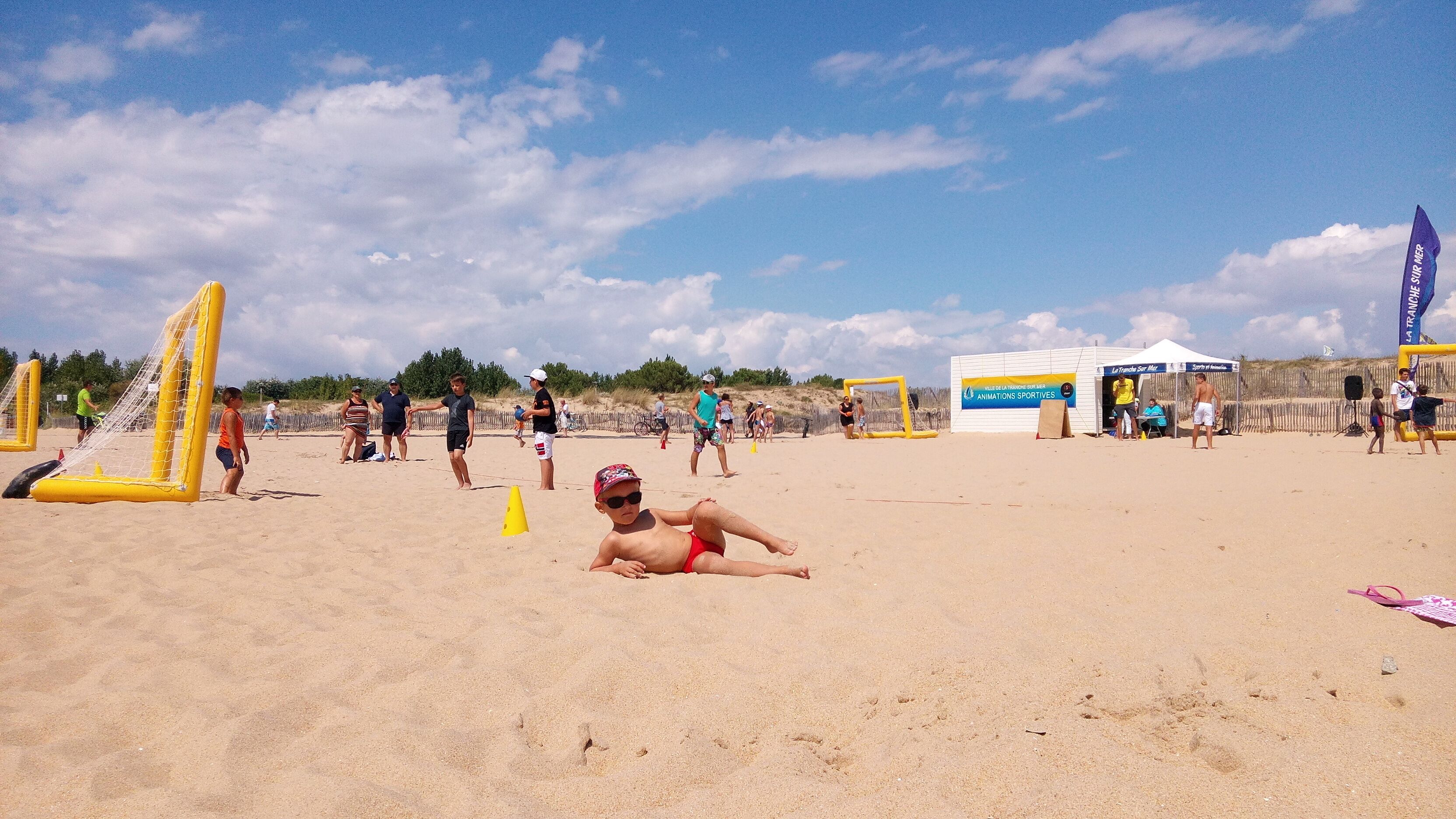 A sandy beach with inflatable structures and a tent.