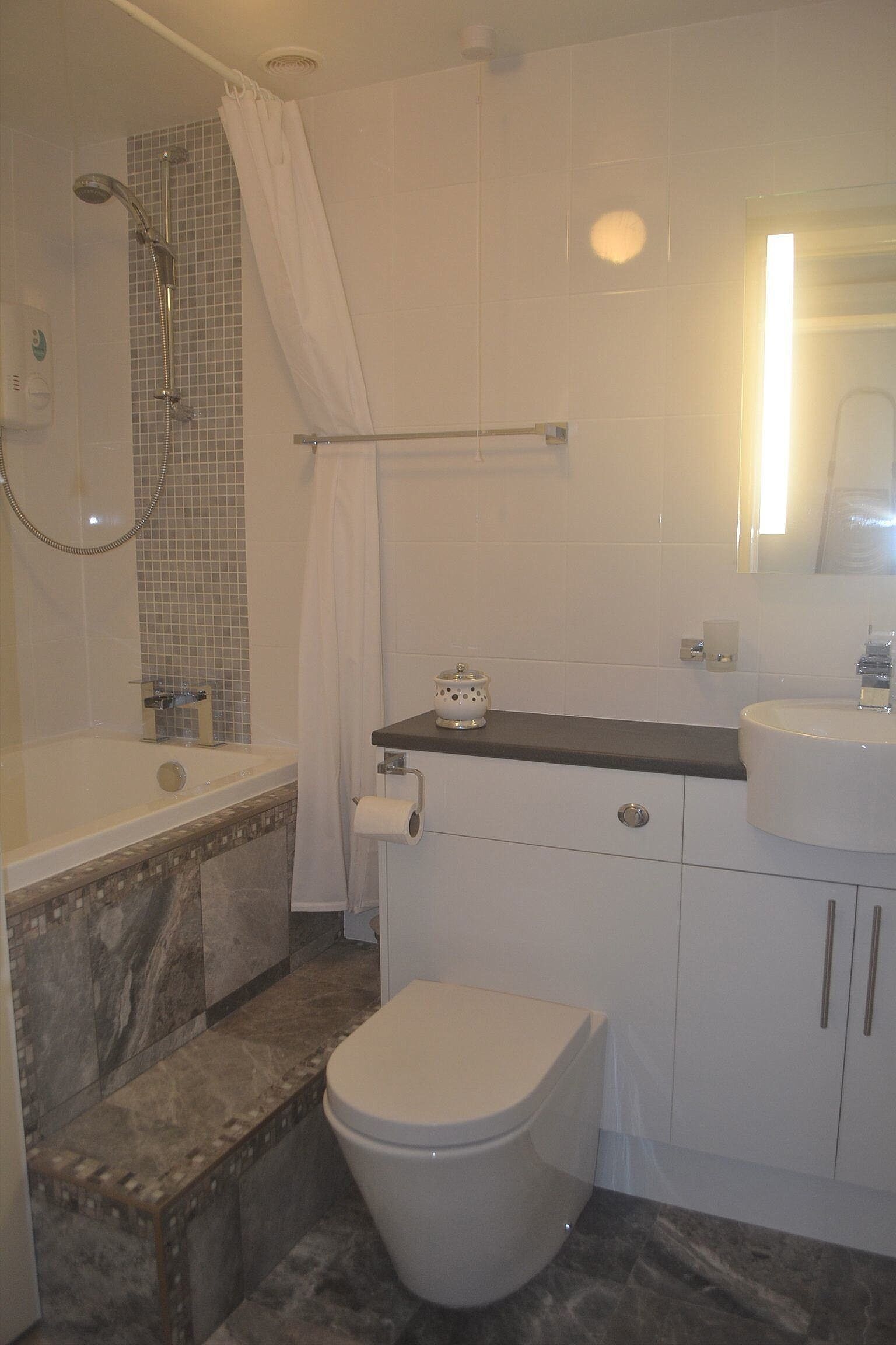 A bathroom with a bathtub, toilet, and sink.