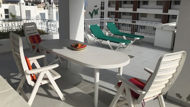 A terrace with white furniture, a table, and a bowl of fruit. - Penthouse With Sea And Mountain View And Communal Swimming Pool  (Nerja)