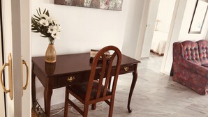 A dining area with a wooden table and chairs, a vase with flowers, and a painting on the wall. - Penthouse With Sea And Mountain View And Communal Swimming Pool  (Nerja)