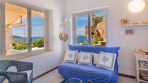 A room with a bed, a chair, and a view of the sea. - Villa Josephine with pool in Costa Paradiso (Costa Paradiso)