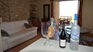 A dining area with a table, a bottle of Grey Goose Vodka, and a glass with bread. - Apartment/ flat - ALGAJOLA (Algajola)
