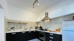 A modern kitchen with black cabinets, a stainless steel sink, and a white countertop. - House Zara Medulin - Beautiful modern house (Medulin)