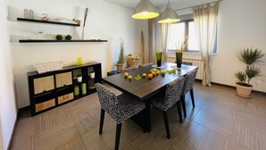 A modern dining area with a dark wooden table, patterned chairs, and pendant lighting. - House Zara Medulin - Beautiful modern house (Medulin)