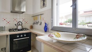 Una cocina con estufa, horno y ventana con vistas al exterior.