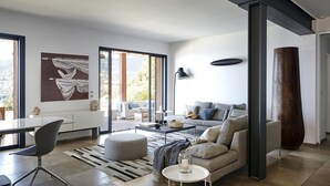 Ein modernes Wohnzimmer mit Sofa, Couchtisch und Essbereich mit Stuhl und Tisch.