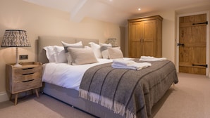 A bedroom with a bed, bedside tables, a wardrobe, and a door. - Orchard Cottage - sleeps 8 guests  in 4 bedrooms (Ilminster)