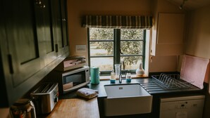 A compact kitchen with a sink, a toaster, a kettle, and a dish rack. - Apple Cottage - A stylish country retreat, it's the ideal getaway. (Wimborne)
