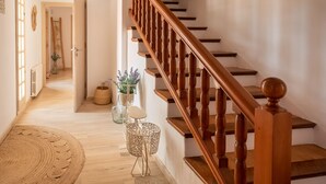 A wooden staircase with a handrail, leading to a landing with a woven rug and a potted plant. - Casa Rosita, free Wifi, 75 meters from the Niu Blau beach, ideal families. (Santa Eulalia del Rio)