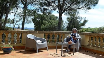 Relax on the terrace with a view of the surrounding landscape, featuring a table and two chairs.