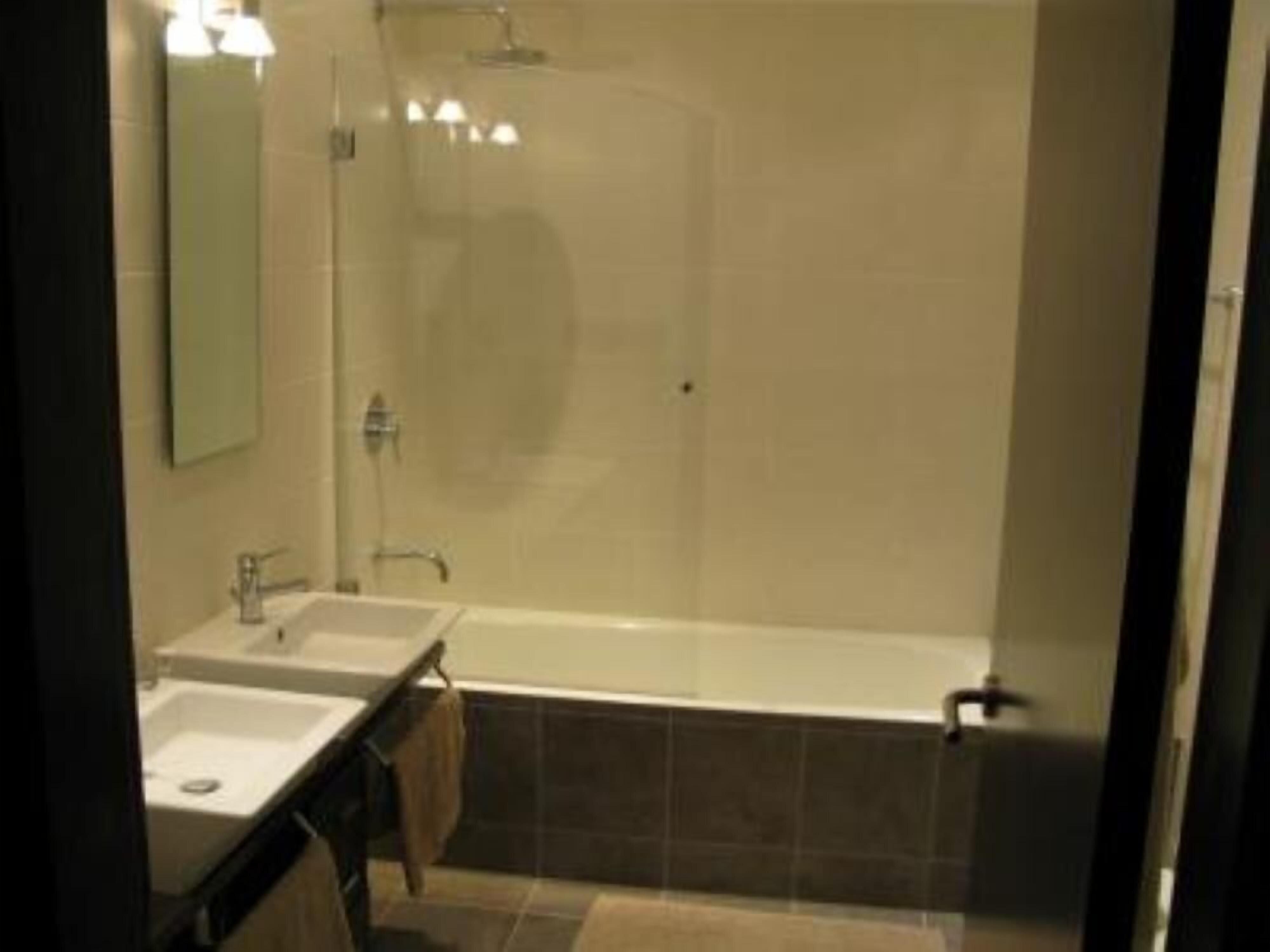 A bathroom with two sinks, a mirror, and a shower.