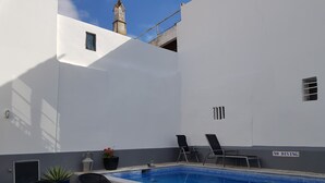 A swimming pool with lounge chairs and a table, a 'NO DIVING' sign, and a small potted plant. - Riverside apartment with private pool in old town - WiFi (Tavira)
