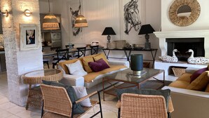 A cozy living room with wicker furniture, a fireplace, and artwork on the walls. - Apartment/ flat - Lagnes-L'Isle-sur-la-Sorgue (lAGNES)