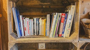 A wooden bookshelf with books and magazines.