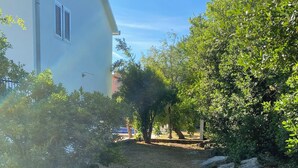 A residential area with a house, a grassy yard, and a tree. - Villa in Gosici, Radovici. Private Pool, BBQ, peaceful location, stunning views. (Gošići)