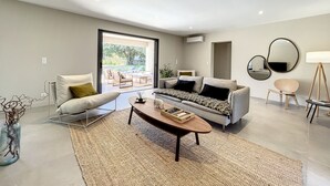 A modern living room with a sofa, coffee table, and a dining area. - Big house  with garden (Sotta)