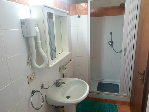 A bathroom with a sink, mirror, towel rack, and shower. - Brigitte, centre, 5 minutes walk to the beach, 10 minutes walk trainstation. (Tropea)