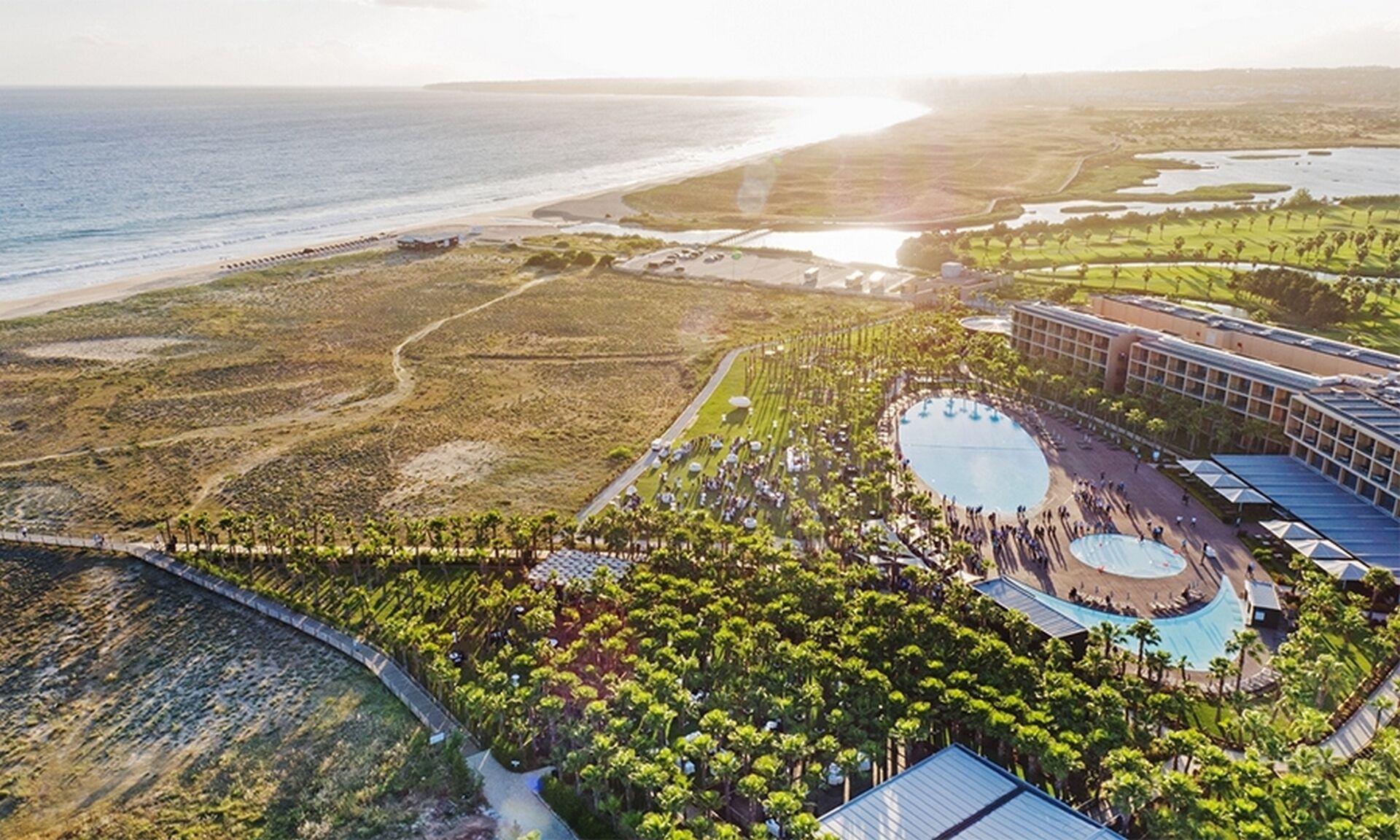 Eine Luftaufnahme eines Resorts mit einem großen Pool, einem Strand und einem Golfplatz.