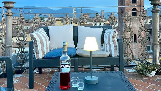 A terrace with a table, a bottle of Campari, and a lamp. - Gabry's Rooftop Terrace Home with  breathtaking Views of Lucca & Tuscany (Lucca)