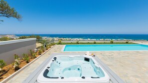 Ein Pool auf dem Dach mit Whirlpool und Meerblick.