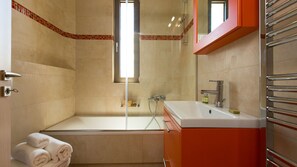 Ein Badezimmer mit Badewanne, Waschbecken und Dusche.