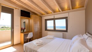 A bedroom with a bed, a window with a view of the sea, a desk, and a chair. - Villa Naya, walking distance to beach & sea view! (Rethymno)