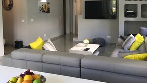 Ein modernes Wohnzimmer mit einem grauen Sofa, einem Couchtisch und einer Obstschale.