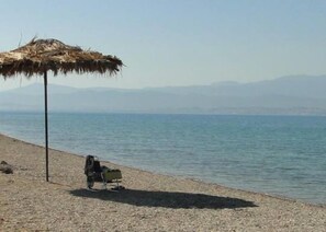 Una playa cerca, sillas reclinables de playa, toallas de playa