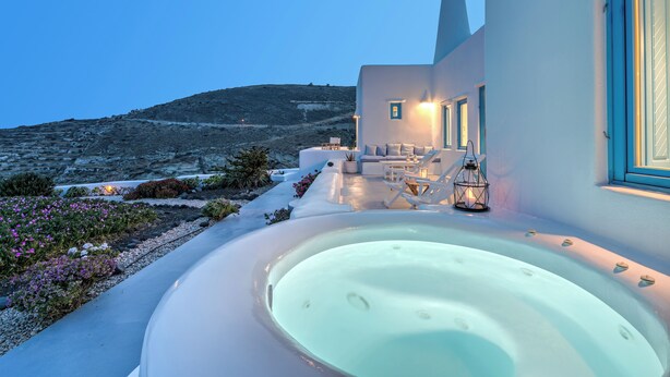 Un bâtiment moderne doté d’un jacuzzi, d’un espace extérieur aménagé et offrant une vue sur une colline.