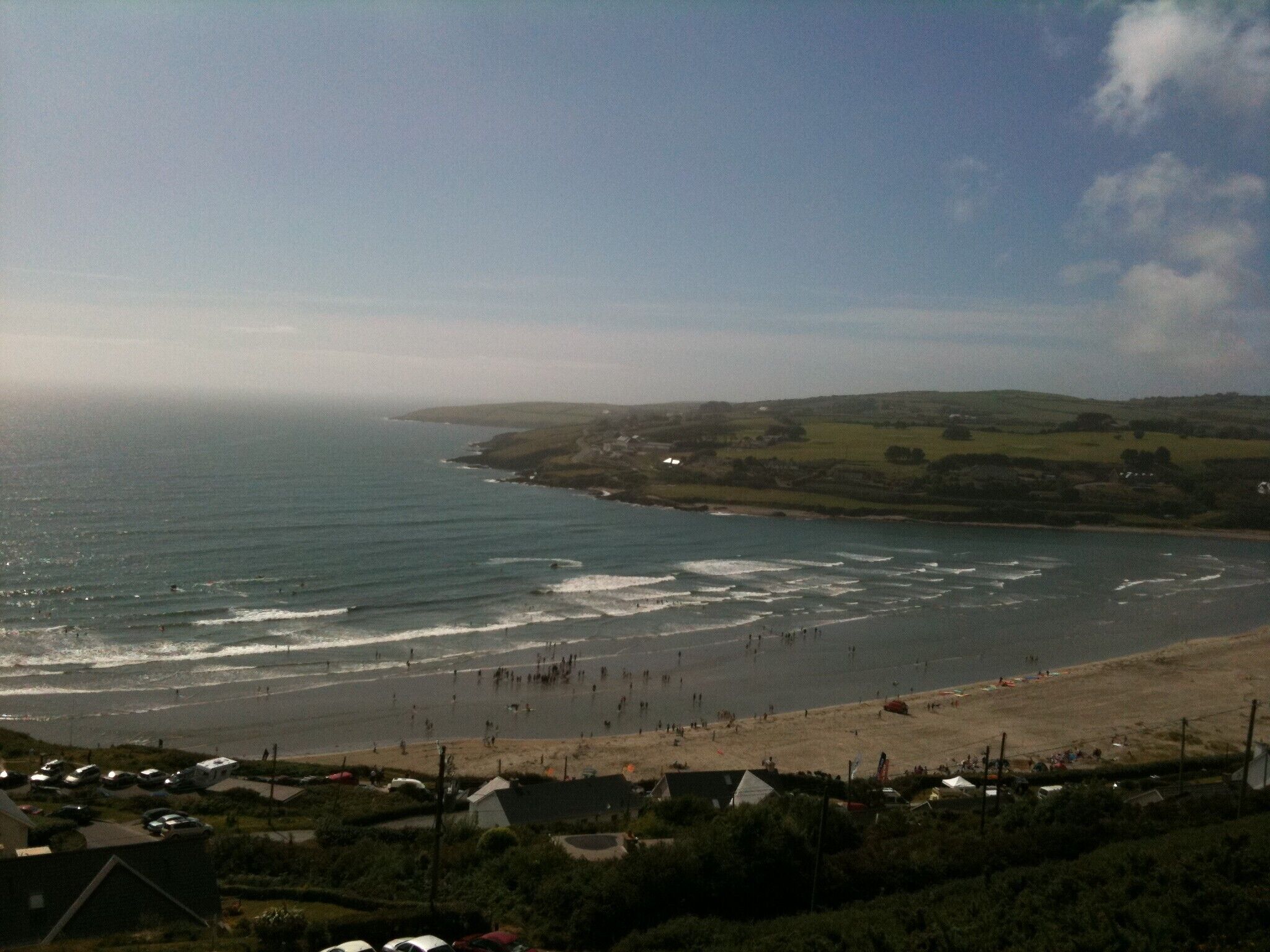 A coastal view with a beach, ocean, and residential area.