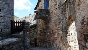 Un edificio antiguo de piedra con una puerta de madera y una puerta pequeña.