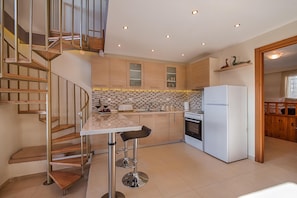 A modern kitchen with a central island, a built-in oven, and a refrigerator.