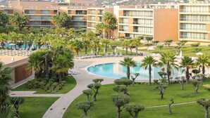 Ein Resort mit Pool, Palmen und Blick auf die umliegenden Gebäude.