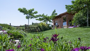 A house with a garden in front, a wooden deck, and a patio area. - Eco country house near Costa Brava. Garden, pool and views (LLADO)