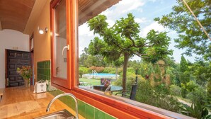 A kitchen with a large window, a sink, and a toaster. - Eco country house near Costa Brava. Garden, pool and views (LLADO)