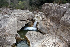 Eine natürliche Felsformation mit einem kleinen Wasserfall und einem Bach.