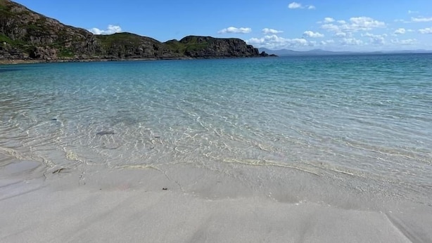 A clear beach with calm waters and rocky hills in the background. - Comfortable Cottage With Spectacular Sea And Mountain Views (Duisdale)