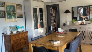 A dining area with a wooden table, black chairs, and a large black pendant light. - Charming villa with pool near downtown in quiet area. (L'isle-Sur-La-Sorgue)