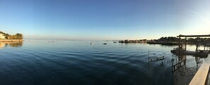 A calm waterfront with a wooden dock and a small boat. - stylish villa with beautiful sea view and heated pool (May to Sept) (Lège-Cap-Ferret)