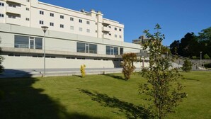 A modern building with a flat facade, large windows, and a well-maintained lawn with a few trees. - “Musical View” – Fabulous view of the “Casa da Música” and surrounding area (Porto)