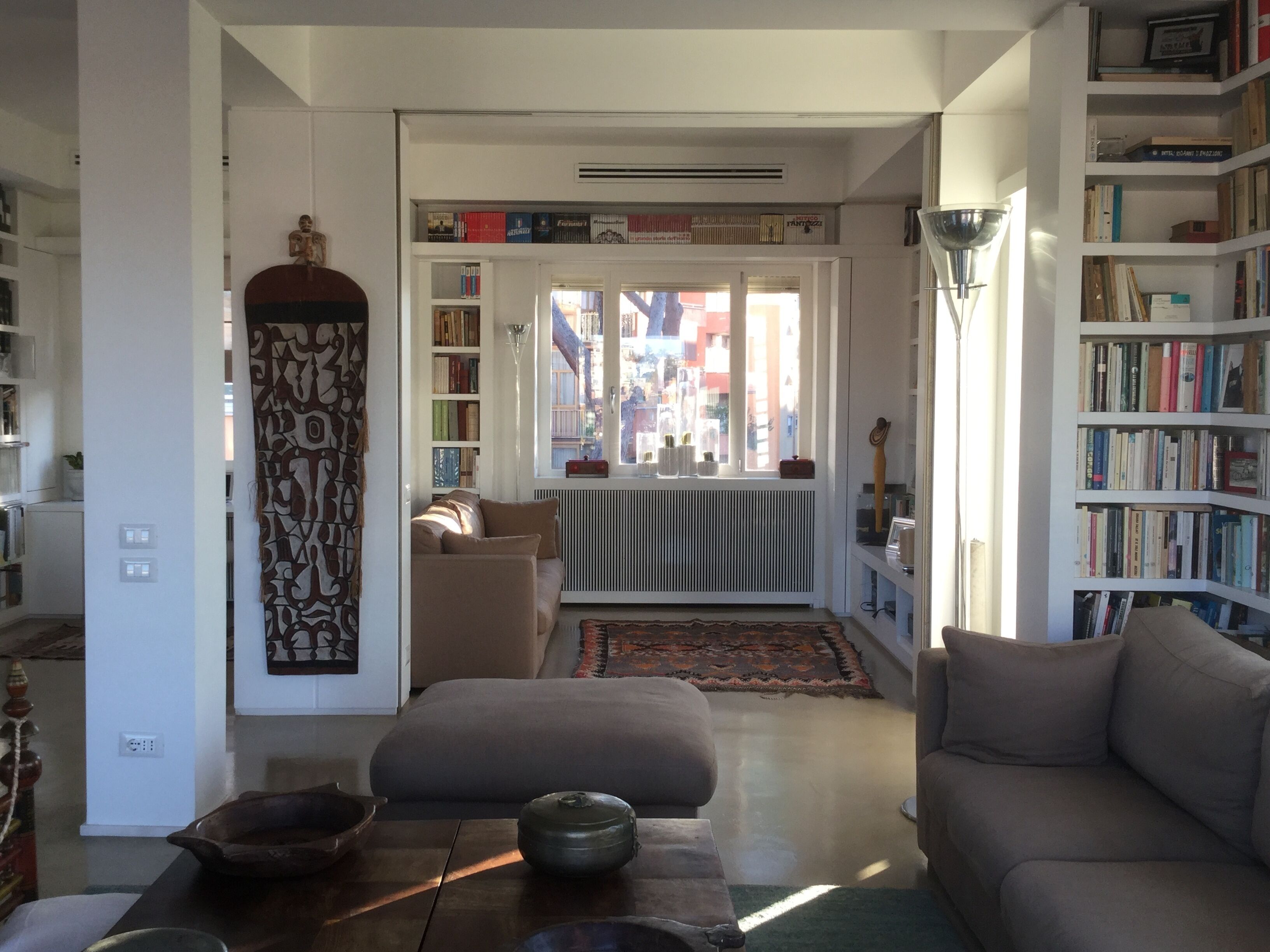 A cozy living room with a sofa, a coffee table, and a bookshelf filled with books.