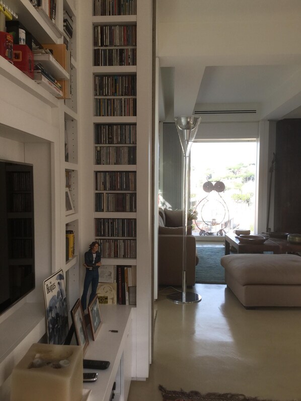 A spacious living room with a large bookshelf filled with books and DVDs, a comfortable sofa, and a modern lamp. - Beautiful penthouse with terraces 10 'walk from the Vatican Museums and Rome Center (Roma)